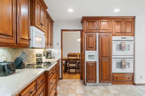 Cook your favorite meals in this elegant kitchen with rich wood cabinetry, granite counters, and premium appliances.
