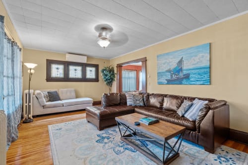 Unwind in this spacious living room featuring rich leather seating and coastal artwork that instantly transports you to peaceful seaside moments.